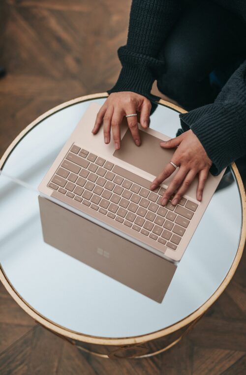 Hands typing on a laptop